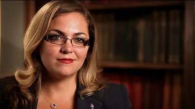 A young woman with glasses looking into the camera
